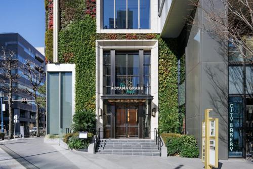 a building with a ivy covered facade with a revolving door at THE AOYAMA GRAND HOTEL in Tokyo