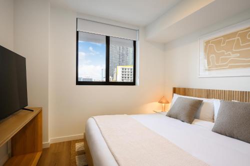 a white bedroom with a bed and a window at Sense28 Edgewater, an AvantStay Hotel in Miami