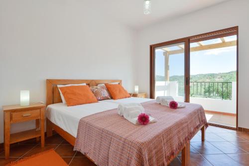sypialnia z łóżkiem i dużym oknem w obiekcie Monte da Ribeira w mieście Estoi