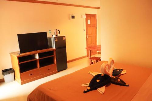 a room with a bed with a tv and a kitchen at Rouge Service Apartments, Soi Buakhao in Pattaya