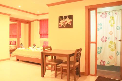 a room with a table and a bed and a bedroom at Rouge Service Apartments, Soi Buakhao in Pattaya