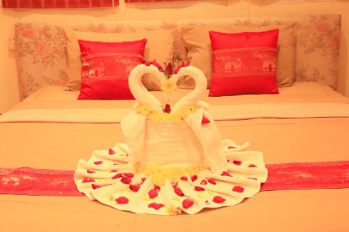 two swans in a wedding dress on a bed at Rouge Service Apartments, Soi Buakhao in Pattaya