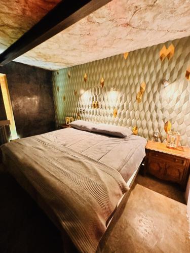 a bedroom with a bed and a stone wall at Macondo Hotel Galería in San Luis Potosí
