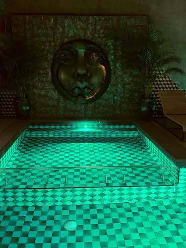 a swimming pool with a face on the wall at Macondo Hotel Galería in San Luis Potosí
