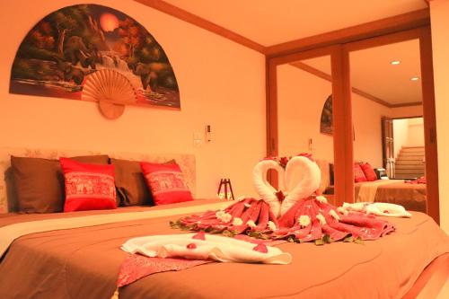 a bedroom with two beds with towels on them at Rouge Service Apartments, Soi Buakhao in Pattaya