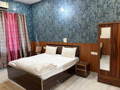 a bedroom with a bed and a blue wall at PLAY HOTEL BLU MOON couple friendly in Greater Noida