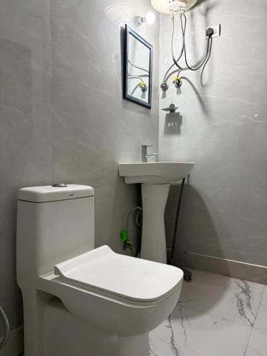 a bathroom with a white toilet and a sink at PLAY HOTEL BLU MOON couple friendly in Greater Noida