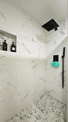 a bathroom with white marble walls and a mirror at Seasun Hostel in Los Angeles