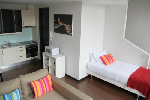 un salon avec un canapé et une cuisine dans l'établissement 12 Short Term, à Porto