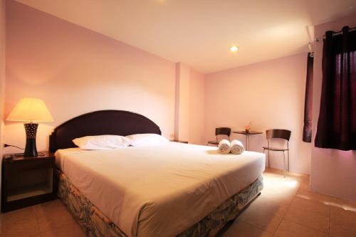 ホアヒンにあるチャバ シャレー ホテルのベッドルーム1室(大型ベッド1台、白い枕2つ付)