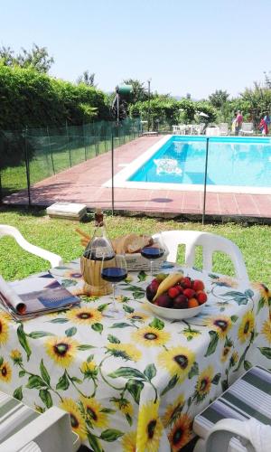 a table with a bowl of fruit on it next to a pool at Agriturismo Il Giardino in Sansepolcro