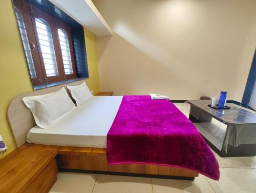 a bedroom with a bed with a purple blanket on it at Aura Villa in Delmāra