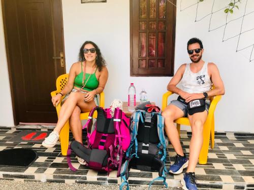 two people sitting in yellow chairs with their luggage at Hasi Villa in Ahungalla