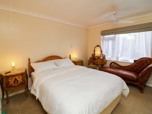 a bedroom with a large white bed and a window at 5 Overstone Drive in Wisbech