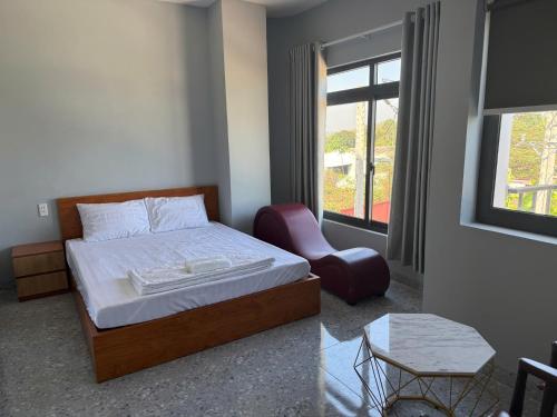 a bedroom with a bed and a chair and a window at Hotel Trần Anh in Xóm Bên Ðông