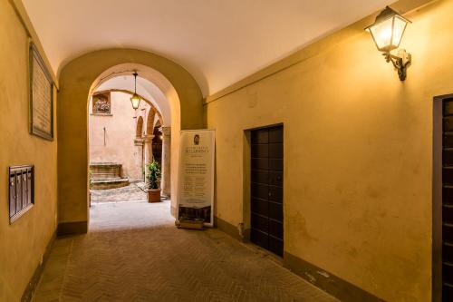 an empty hallway with an archway and a door at Appartamenti Bellarmino in Montepulciano