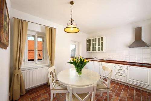 a kitchen with a white table and chairs and a window at Pension Rozmarýna in Český Krumlov