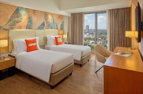 a hotel room with two beds and a desk at Alino Hotel in Manila