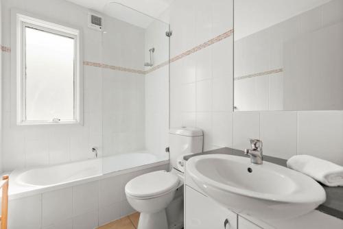 a white bathroom with a toilet and a sink at Three Bears 3 - Thredbo in Thredbo