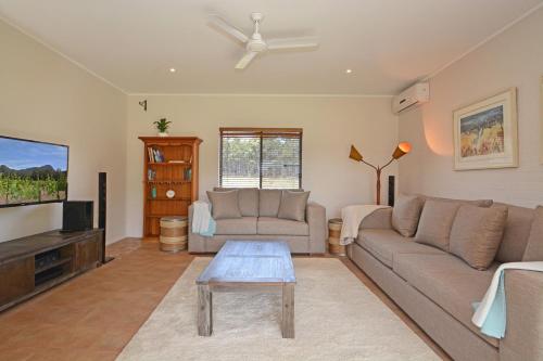 a living room with a couch and a flat screen tv at JE Guesthouse, central to all the Hunter Valley has to offer in Pokolbin