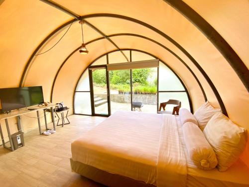 a bedroom with a large bed with a large window at Azana Essence Selo Boyolali in Boyolali