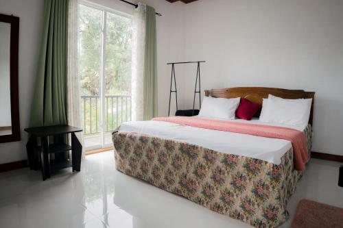 a bedroom with a large bed with a window at Bloom house homestay in Bandarawela