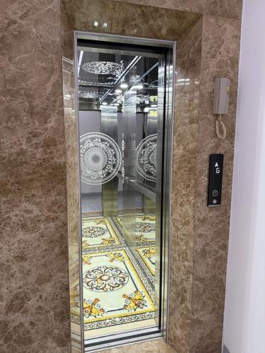 a glass elevator in a room with plates on the wall at Hotel Trần Anh in Xóm Bên Ðông
