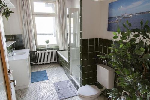 a bathroom with a toilet and a shower and a sink at Stilvolle Altbauwohnung in zentraler Lage in Kiel