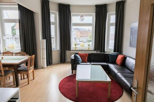 a living room with a black couch and a table at Stilvolle Altbauwohnung in zentraler Lage in Kiel