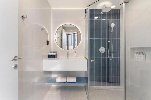 a bathroom with a shower and a sink and a mirror at Amigo Sol Phan Thiet in Phan Thiet