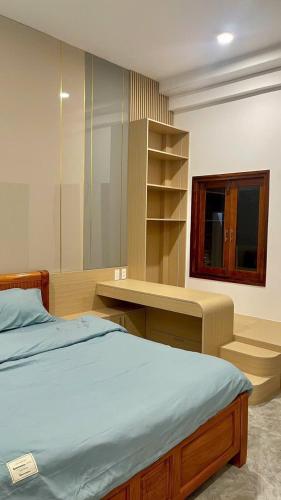 a bedroom with a bed and a desk and a shelf at Sun Homestay Doclet in Doc Let