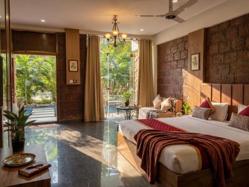 a bedroom with a bed and a living room at Udaya Resort in Palakkad
