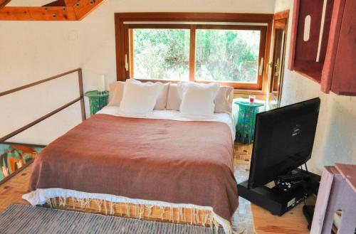 AiguesにあるCasita Camino Viejoのベッドルーム1室(ベッド1台、テレビ、窓付)