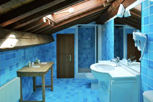 a blue bathroom with a sink and a toilet at Palazzo Raspanti in Treviso