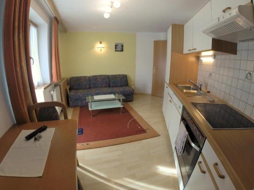 a kitchen and a living room with a couch at Appartement Pension St. Sebastian in Pettneu am Arlberg