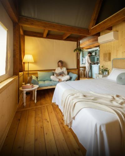 a woman sitting on a couch in a bedroom at Saturnia Glamping - Seme di Carota in Saturnia