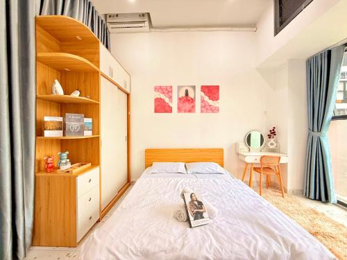 a bedroom with a bed with a book on it at The Sun Avenue - TPHomes in Ho Chi Minh City