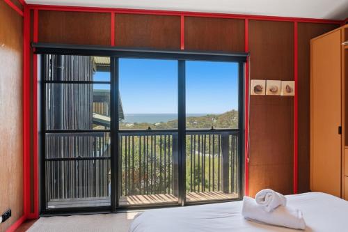 a bedroom with a large window with a view of the ocean at 2/38 Booran Street in Point Lookout