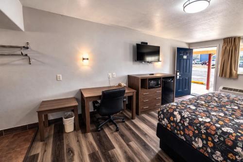 a hotel room with a desk and a bed and a bed and a desk at American Inn & Suites in Paris