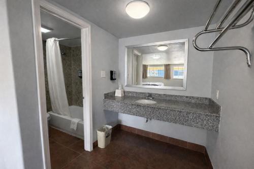 a bathroom with a sink and a mirror at American Inn & Suites in Paris