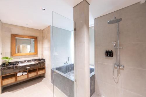 a bathroom with a shower and a sink at Anumana Ubud Hotel in Ubud