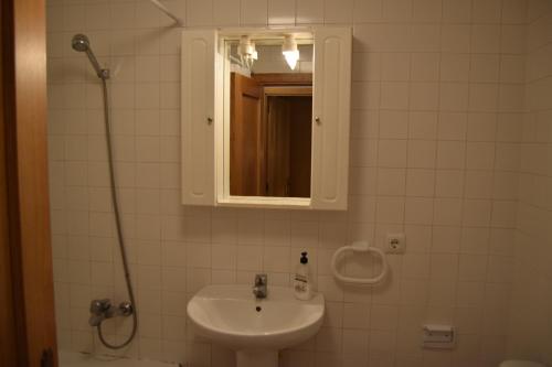 Un baño con lavabo, espejo y ducha. en Apartaments Bizantí, en Sant Martí d’Empúries