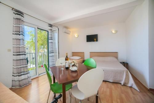 a bedroom with a bed and a table and chairs at Apartmani More in Gradac