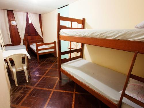 Pokój z 2 łóżkami piętrowymi, stołem i krzesłami w obiekcie Hostel Amazonia w mieście Belém