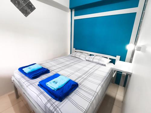 a bed with two blue pillows on top of it at Pintu Biru Hostel in Wamena
