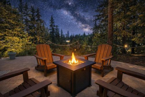 a patio with two chairs and a fire pit at night at River Song Cabin home in Leavenworth