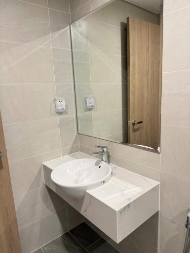 a bathroom with a white sink and a mirror at Motel Happy House- Hảo in Bạc Liêu