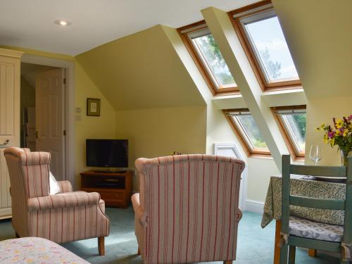 a living room with two chairs and a tv at Gwel An Lowarth in Lostwithiel