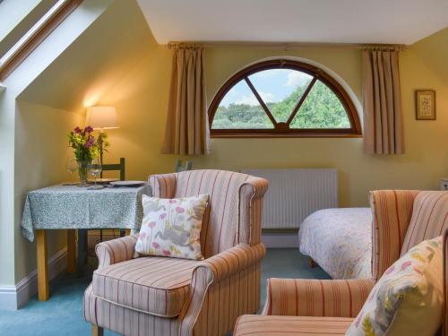 a room with a bed and a table and chairs at Gwel An Lowarth in Lostwithiel