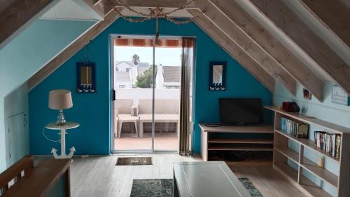 a room with an attic with blue walls at Anchorage in Stompneusbaai